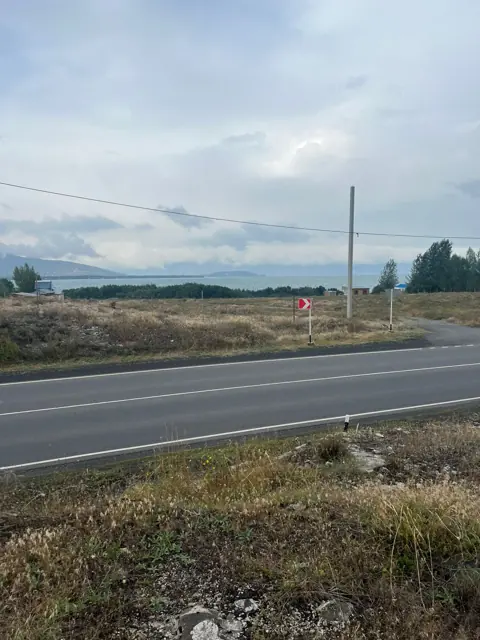 Трасса и съезд, за береговой полосой – озеро
